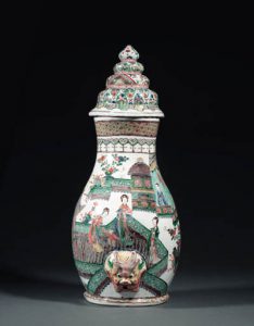 A RARE FAMILLE VERTE WALL FOUNTAIN AND COVER kangxi The pear-shaped body enamelled with elegant ladies in conversation on a terrace in front of pavilions below a ruyi-cloud collar and a trellis-pattern band at the mouth, the lower section modelled in relief with lion-mask spout, the domed cover with geometric and floral motifs in four registers, some restoration 22 in. (55.5 cm.) high 