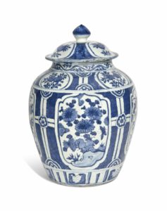 A CHINESE BLUE AND WHITE 'KRAAK PORSELEIN' JAR AND COVER WANLI PERIOD (1573-1619) Decorated with shaped panels enclosing flowers and rocks, reserved on a diaper ground with strapwork, the cover similarly decorated 18 ½ in. (47 cm.) high