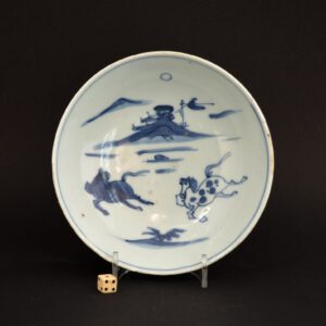 A Transitional Porcelain Ko-Sometsuke Bowl, late Ming Dynasty, Tianqi period 1621-1627 or early Chongzhen, c.1625-1635. The shallow 17th century Chinese bowl is decorated with two prancing horses in a landscape in the foreground, the background consists of buildings with a flag perched on top of a rocky outcrop. Condition very good, minor fritting. Size Diameter : 14.5 cm (5 3/8 inches) Provenance N/A Stock number 24514 References For a Ming blue and white porcelain dish with this design from the Butler Family Collection see : Trade and Transformation, Jingdezhen Porcelain for Japan, 1620-1645 (Julia B.Curtis, China Institute Gallery, New York 2006) page 78, plate 54.
