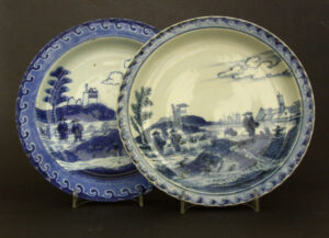 Two Blue and White 18th Century Porcelain Plates Painted with the So-Called Deshima Island Pattern. One Japanese, Arita Kilns c.1700-1740 the other Chinese Export Porcelain, Yongzheng Period 1723 - 1735. These Plates are Decorated in The Style of The Dutch Delft Pottery Decorator Frederik Van Frytom (1632 - 1702). The Scene Used to be thought of as Deshima Island However it is now Thought to be a View of Holland.Plates and Dishes of this Pattern were Recovered from the Ca Mau Shipwreck.