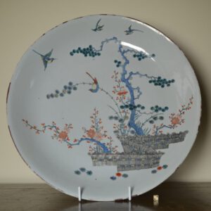 A rare large Chinese export porcelain saucer shaped dish, entirely decorated in Holland in the Kakiemon style with the ‘Three Friends of Winter’. The porcelain is late Kangxi or early Yongzheng and was made in around 1720, the decoration dates to c.1720-1725, it includes ‘banded-hedges’ and is quite faithful to the Japanese Kakiemon original. It is highly unusual to find such a large piece of Chinese porcelain that is entirely enamelled in Holland, plain Chinese dishes of this size are extremely rare if they exist at all, so it is highly likely this dish was ordered especially with the intention of decorating it when it arrived. Therefore the Chinese porcelain dates to c.1720-25.