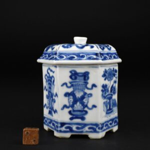 A Rare Kangxi Porcelain Jar and Cover, Late Kangxi c.1690-1710. This hexagonal Blue and White porcelain from the Morpurgo Family container is perhaps a spice box or a maybe a container for sugar. The box is decorated in a version of the ‘Hundred Antiques’ design, these include vases of flowers, books, scrolls etc, the cover incorporates some of the ‘Eight Precious Objects’ (see below for more details about the Eight precious Objects). This small Kangxi object sits on six shaped feet. Although undoubtedly made for use, such items were often incorporated into large Baroque displays in large houses and castles during what became known as ‘China Mania’. For more details about the The Morpurgo Family Collection see ‘Provenance’.SOLD Condition In extremely good condition. A couple of minute frits c.1mm. Size Height 9 cm (3 1/2 inches) Provenance The Morpurgo Family Collection - This collection was formed thanks to four successive generations of the Amsterdam Morpurgo family. The first, Joseph Morpurgo, started with no experience of the world of antiques and collecting. Thereafter, each generation sought to improve the breadth of their expertise and also the quality of the works they were acquiring. The collection reflects Dutch taste of the late 19th and 20th century, it was not just a collection of oriental ceramics. It included Dutch Delftware, silver and glass. Stock number