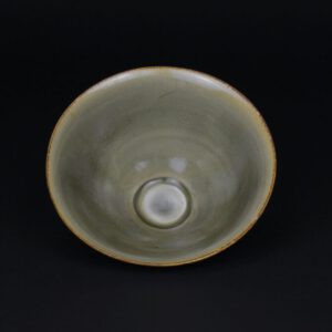 A Small Fine Yaozhou Celadon Ware Bowl from the Yaozhou Kilns in Shaanxi or Henan Province, Northern Song (960 – 1127) or Jin dynasty (1115 – 1234). This small Yaozhou conical bowl exhibits typical Yaozhou traits, for example the footrim, the lightness of potting and larger but few bubbles than Longquan celadon. The glaze is very shiny, it is clear with small bubbles and of an olive-green tone. The most accurate representations of the colour are the photographs of the interior of the bowl.SOLD Condition Perfect but with some kiln grit to the lower exterior of the bowl. Size Diameter : 11 cm (4 inches). Provenance From a Private American Collection Stock number 26012