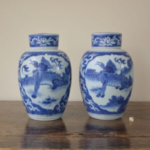 A pair of Transitional Porcelain jars and covers, late Ming porcelain from Chongzhen period c.1643. Recovered from the ‘Hatcher Junk’ and sold in Christie’s in Amsterdam in 1984. The well painted jars are decorated in rich tones of cobalt blue with a cracked-ice ground with two leaf-shaped reserves, one containing a Phoenix with the other depicting a Qilin. The crack-ice ground is painted with flowering lotus and peony. The tops of the flat covers are decorated with lotus.