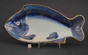 An 18th Century Japanese Porcelain dish in the form of a sea-bream c.1700-1730. The moulded form is painted in broad brush strokes of dark cobalt blue using a wet brush. The blue has settled between the scales along the paler inner edge. The lower area of the fish has a feint orange lustre wash, gilding has been employed to delineate the gills, eyes, mouth and some of the scales. The base with a Ming four character mark.SOLD Condition In excellent condition. A minute chip to the foot rim c.1 x 1 mm. Minor kiln smoke marks to the back. Size Length : 25.3 cm (10 inches) Provenance N/A Stock number 24191 References For a very similar Japanese Arita porcelain fish dish dated to c.1690-1730 see : Complete Catalogue of Shibata Collection (Kyushu Ceramic Museum, 2003) page 325, plate 2542. For a very similar Japanese blue and white porcelain fish dish dated to c.1690-1730 see : Complete Catalogue of Shibata Collection (Kyushu Ceramic Museum,2003) page 325, plate 2542. For a similar Japanese Porcelain dish see : The Catalogue of The Shibata Collections, The Exhibition (1) (Akihiko Shibata and Yuko Shibata and others, The Kyushu Ceramic Museum, 1990) Page 153 plate 397. 