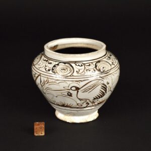 A Small Ming Cizhou Type Painted Jar, Mid-16th Century. This small guan type stoneware jar is painted in iron-oxide on a cream slipped ground, the thin glaze stops above and below the last iron-brown line, above the splayed foot. The interior is glazed in brown iron-oxide. Using quickly applied marks the painter has created a lively design, comprising of two joined panels, each showing a crane among plants. Post-Yuan Cizhou ware is often rather difficult to date, and pieces like the present example are often dated earlier than they should be. This jar with its distinctive painting style closely relates to a larger, more sophisticated jar, dated 1541 (Ming, Jiajing Period) in the Herbert F. Johnson Museum of Art, Cornell University. This dated jar is illustrated in Freedom of Clay and Brush through Seven Centuries in Northern China (see references). The name Cizhou originated from the ancient area of Cizhou, encompassing a broad arc across China, which was first recorded during the Sui dynasty (581-618). However, the location constantly shifted and though the area of Cizhou is mentioned in the Tang dynasty (618-906) and Five Dynasties (906-960), each referred to an altered location. During the Song, Jin (1125-1234), Yuan (1279-1368), and partly into the Ming dynasties (1368-1644) the kiln areas of Cizhou were primarily concentrated in the northern provinces of Hebei, Henan, and Shaanxi.SOLD Condition There are two large chips to the flared base. Despite the top rim being glazed this Ming jar would have had a cover. Size Height 9.7 cm (3 3/4 inches) Provenance From a Japanese collection. Stock number 26452 References Freedom of Clay and Brush through Seven Centuries in Northern China ; Tz'u-chou Type Wares 960-1600 ( Yutaka Mino, Indiana University Press. ISBN 0-253-25575-6)