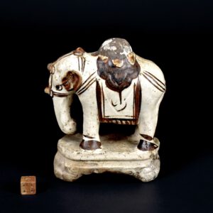 A Small Ming Cizhou Type Painted Model of an Elephant, 16th Century, Probably Jiajing or Wanli c.1550 – 1600. This small model of an elephant is painted in iron-oxide over a cream slipped ground, the thin glaze stops above the lower part of the base, which four feet. This unusual model is incomplete, there would have been a decorative element on the elephants back in the form of a lotus flower, perhaps it was an incense or candle stick holder. Such objects were used on family or temple shrines. The name Cizhou originated from the ancient area of Cizhou, encompassing a broad arc across China, which was first recorded during the Sui dynasty (581-618). However, the location constantly shifted and though the area of Cizhou is mentioned in the Tang dynasty (618-906) and Five Dynasties (906-960), each referred to an altered location. During the Song, Jin (1125-1234), Yuan (1279-1368), and partly into the Ming dynasties (1368-1644) the kiln areas of Cizhou were primarily concentrated in the northern provinces of Hebei, Henan, and Shaanxi. See below for more photographs and references. SOLD Condition Poor, the top is missing, it was probably an incense or candle stick holder, which would have been of lotus form. You can see its lotus petal edge on the top of the elephant. The missing section has been hidden with a painted plaster like material. There is a crude repair to the outside of part of the base, below the elephants back left leg. Size Height 11.7 cm (4 1/2 inches). Length 10.6 cm (4 1/4 inches). Provenance Nicholas de la Mare Thompson (1928-2010). Stock number 26661