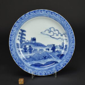 A Yongzheng Blue and White Porcelain Plate 1723-1735. This shaped plate is painted in the style of a famous Dutch Delft artist, Frederik Van Frytom (1632 – 1702). The scene is thought to represent Scheveningen, on the coast of the Netherlands, with its Church, ships and sand dunes, it had been referred to as Deshima Island but all Van Frytom’s work depicts the Netherlands. It is heavily potted with little variation in thickness, that is probably because it was based on a Japanese version of this design. This plate has ‘oriental’ style clouds in the landscape. This dish has clouds that are in the style of Van Frytom, the plates of this design from the Ca Mau wreck have distinctly oriental clouds. The moulded undulating border is quite distinctive, the painting of the border uses wax resist to separate the dark outer blue with the paler cobalt wash which frames the design. This moulded and painted border is used on several other Japanese porcelain designs which are dated between to c.1690 and 1730.See Below For More Photographs and Information. SOLD Condition Minor glaze chips and fritting, a small amount of very minor crazing to the front Size Diameter 19.4 cm (7 1/2 inches) Provenance N/A Stock number 27082 References For more about this delft artist see : Frederik Van Frytom 1632 - 1702, Life And Work Of A Dutch Pottery-Decorator By A.Vecht ( Scheltema and Holkema NV, Amsterdam, 1968). For Japanese and Chinese porcelain in the style of Van Frytom see lower down the page.
