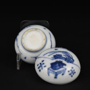 A Transitional Porcelain Box and Cover From the Hatcher Cargo, Late Ming, Chongzhen c.1643. The small circular porcelain box and cover is decorated with a fan panel with grasses and above it a scholars rock, below that is a table with a plant pot. The base is decorated with branches. Condition In very good condition, minute frits to the inside of the cover, almost no signs of it being in the sea. Adhesive to base, probably the remains of the original label. Size Diameter 5.1 cm (2 inches) Height 3.4 cm (1 1/3 inches) Provenance Purchased in the 1980's from one of the original Hatcher Cargo auctions. It lacks a Hatcher label. Stock number 26088 References A Transitional Blue and White Porcelain Box and Cover of this type with a cricket is in the British Museum, see : Catalogue of Late Yuan and Ming Ceramics in the British Museum.(Jessica Harrison-Hall.The British Museum Press, 2001. ISBN 0-7141-1488-X.) page 391, item 12:95. Auction Catalogue - Fine And Important Late Ming And Transitional Porcelain, Recently Recovered from an Asian Vessel in the South China Sea. Property of Captain Michael Hatcher. Christie`s Amsterdam 14th March 1984.