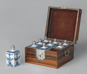 Fig. 10. Case with nine bottles, ca. 1680–1700. Batavia (box) and Japan (bottles). Calamander wood, underglaze painted porcelain, silver, velvet; box: 10⅝ × 10⅛ × 6½ in. (27 × 25.5 × 16.5 cm); bottle height, with cap: 6 in. (15 cm). Rijksmuseum, Amsterdam, NG-444. Image in the public domain.
