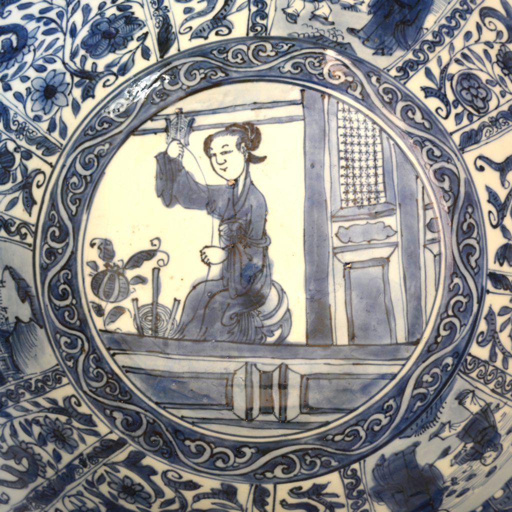 A very large rare Ming Kraak porcelain bowl, Chongzhen period 1628-1644. The exterior is not in the Kraak style but is more Chinese, with a scene taken from a popular Chinese legend or story with a warrior leader with a temporary loose material screen behind him and other figures as well as an extensive landscape. The interior of this deep bowl is typical of late Kraak ware with its panels of landscapes with figures and rather European looking buildings. The well of the bowl is decorated with a lady spooling silk, sometimes referred to as the ‘spinning’ design. This unusual domestic scene is found on a number of bowls of this type but was is rare about this bowl is the contrast between the Kraak interior and the ‘Transitional’ style of the exterior. The quality of painting, with it’s rather loose free brushwork, is reminiscent of Transitional porcelain made for the Japanese market. Indeed I think it is highly likely that many of the workshops in Jingdezhen produced Kraak ware as well as porcelain for the Japanese market. However the present example is very much in Dutch taste.SOLD Condition Four large sections from the rim restuck. Small chips filled. Size Width : 36 cm (14 inches) Provenance Amsterdam (Christie's or Sotheby's) R&G McPherson Antiques The Roy Davids Collection of Chinese Ceramics, Purchased June 1st 2002. Collection label to the base no. 140. Stock number 24605 References For three bowls in this late Kraak style that incorporate transitional porcelain elements see : Kraak Porcelain, A Moment in the History of Trade (Maura Rinaldi, Bamboo Publishing,1989) Pages 163 - 164 Plates 202 - 204. Plate 202 includes the 'spinner' design, but none have a continuous to the exterior. Dated c.1635-1650. For another large Kraakware bowl of this type with a 'spinning' scene to the well but again without the rare continuous scene to the interior see : Kraak Porcelain, The Rise of Global Trade in the Late 16th Century and Early 17th Century (Jorge Welsh Book, London. 2008. ISBN 0-9550992-9-3) page 314, plate 59. Dated 1628-1644. A further Ming porcelain bowl of this type is illustrated in : Chinese Porcelain in the Collection of the Rijksmuseum Amsterdam, The Ming and Qing Dynasties (Christiaan Jorg, Phillip Wilson, The Rijksmuseum, 1997) page 64, plate 48.