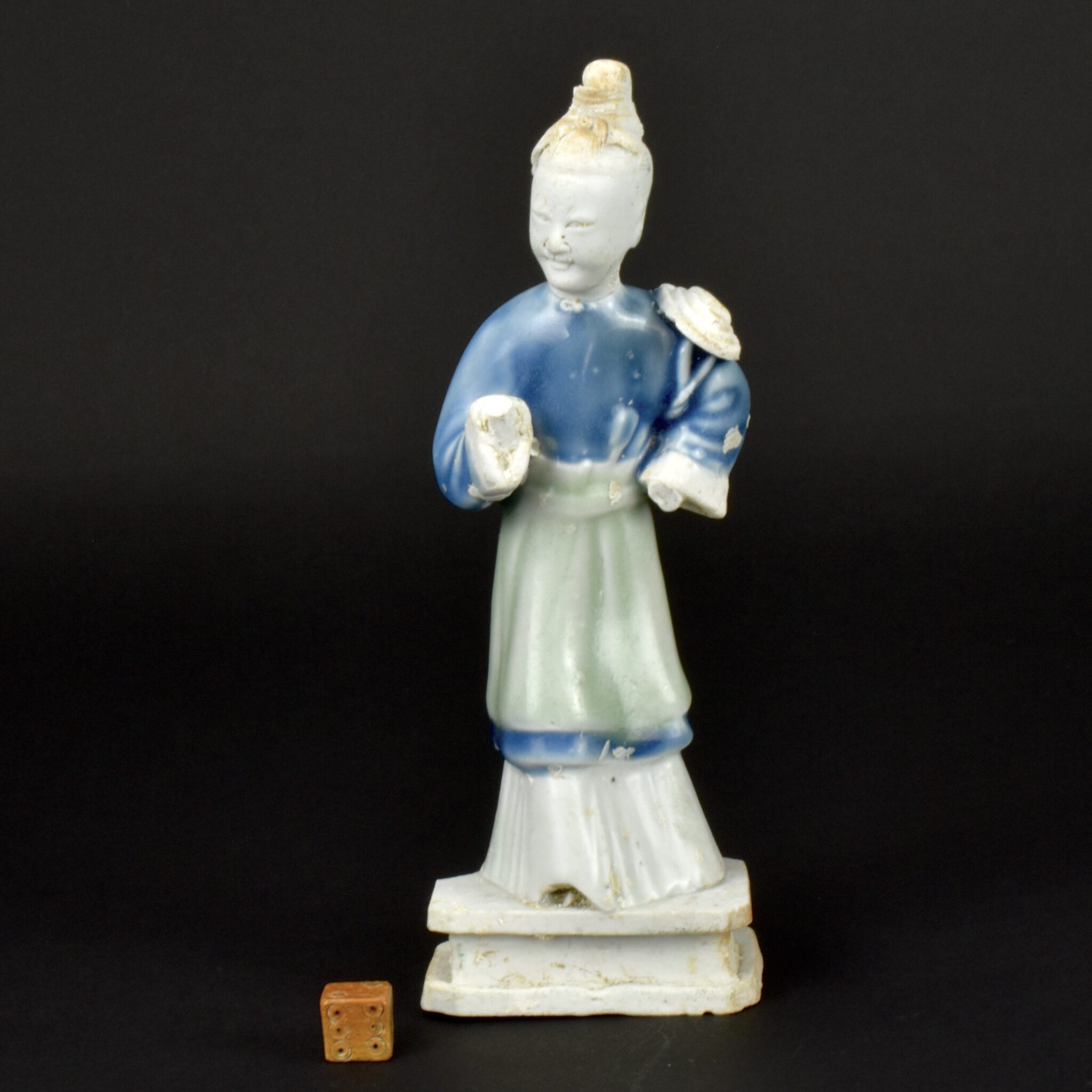 Qianlong Period c.1751, Probably Jingdezhen Kilns. Sold at Christie's Amsterdam in 1986, this very rare figure from the cargo sold for Fl.22,040 (Dutch Guilders) equivalent to €10,000  (£8,728) in 1986. A Chinese export porcelain porcelain figure of a woman standing on a plinth, the biscuit porcelain has areas that are glazed in celadon green and cobalt blue. The undecorated biscuit porcelain face was perhaps originally cold-painted. This Chinese porcelain figure is illustrated on the front cover of the Nanking Cargo catalogue, and in the catalogue as well as in several books (see References) This is a very rare survival from the wreck of the V.O.C. (Verenigde Oostindische Compagnie) ship the Geldermalsen, referred to as The Nanking Cargo, would have be part of the privileged Private Trade allowed by V.O.C. to the Captain and officers of the ship. This figure is illustrated in the Christie's catalogue of the action of 1986, and Dr. Christiaan Jörg's book 'The Geldermalsen, History and Porcelain' and also 'The Nanking Cargo' by Michael Hatcher with Antony Thorncroft (see references). Fragile objects like this figure pf a woman was stored away safely by the officers, they were allowed to sell them to supplement their income from the V.O.C.