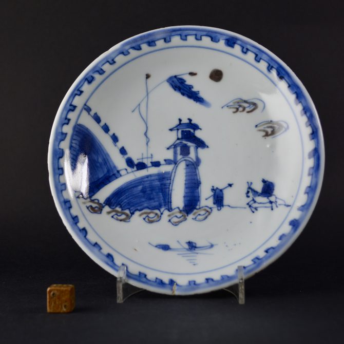 A Ming porcelain, Transitional period, Tianqi or early Chongzhen. This dish was made for the Japanese market and is decorated in underglaze cobalt-blue with touches of underglaze copper-red. The scene depicted is of a large arch in a fortified wall with a figure on horseback and his attendant in tow.SOLD Condition In excellent condition, very minor fritting. Size Diameter : 21.2 cm (8 1/4 inches) Provenance From a Private English Collection of 17th and 18th Century Chinese and Japanese Porcelain. Stock number 24967 References For a Ming porcelain dish with a very similar design in cobalt blue and copper red see : Seventeenth Century Jingdezhen Porcelain from the Shanghai Museum and the Butler Collection (Shanghi Museum,2006. ISBN 1-85759-417-7) page 56 plate 18.